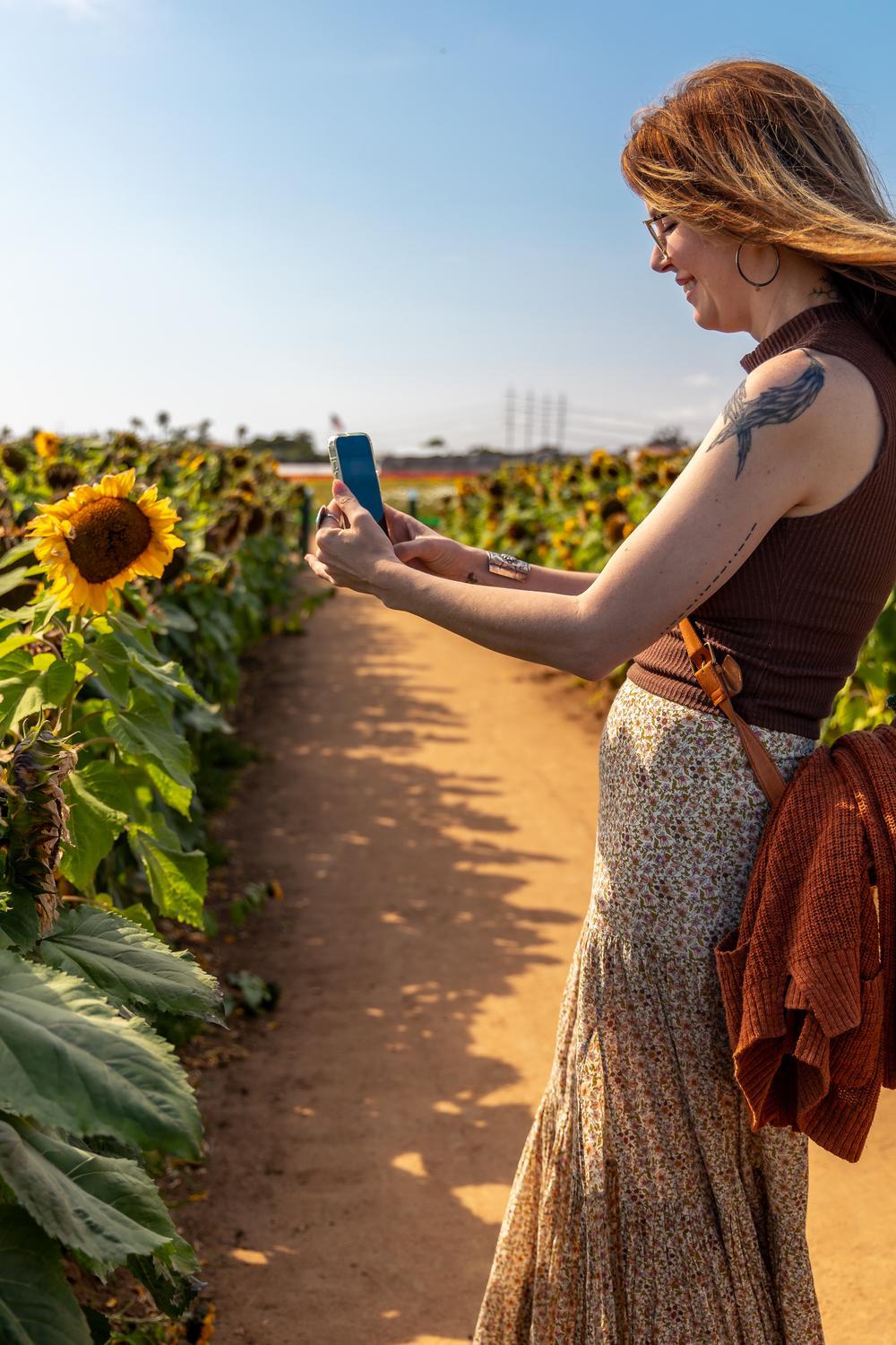 The Flower Fields Carlsbad, CA person with sunflowers