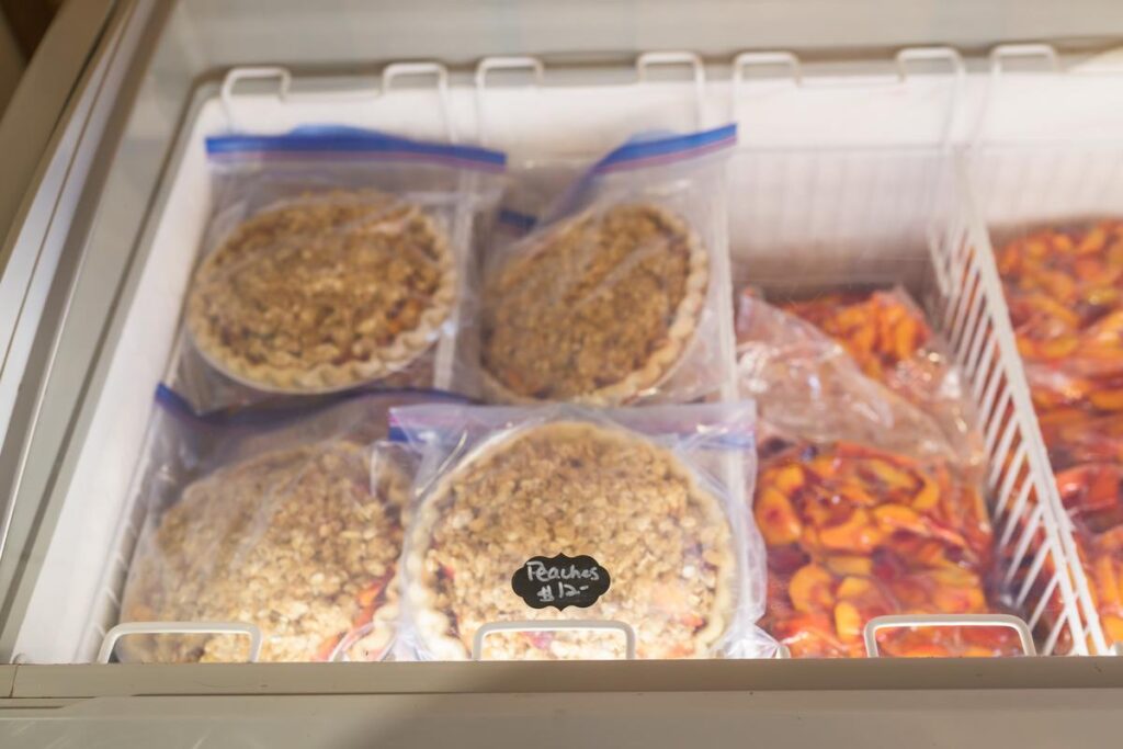 peach pies and sliced peaches in deep freezer
