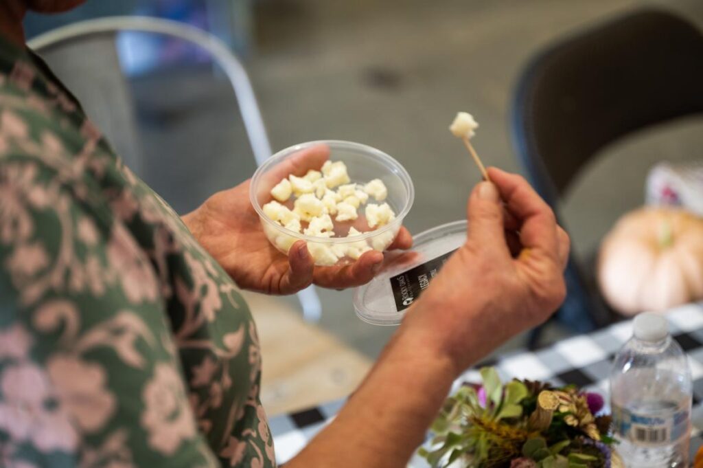 woman with a cheese sample on a toothpick