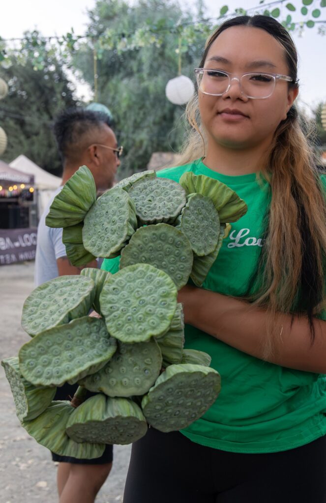 Lyla holding a bouquet of lotus seed pods