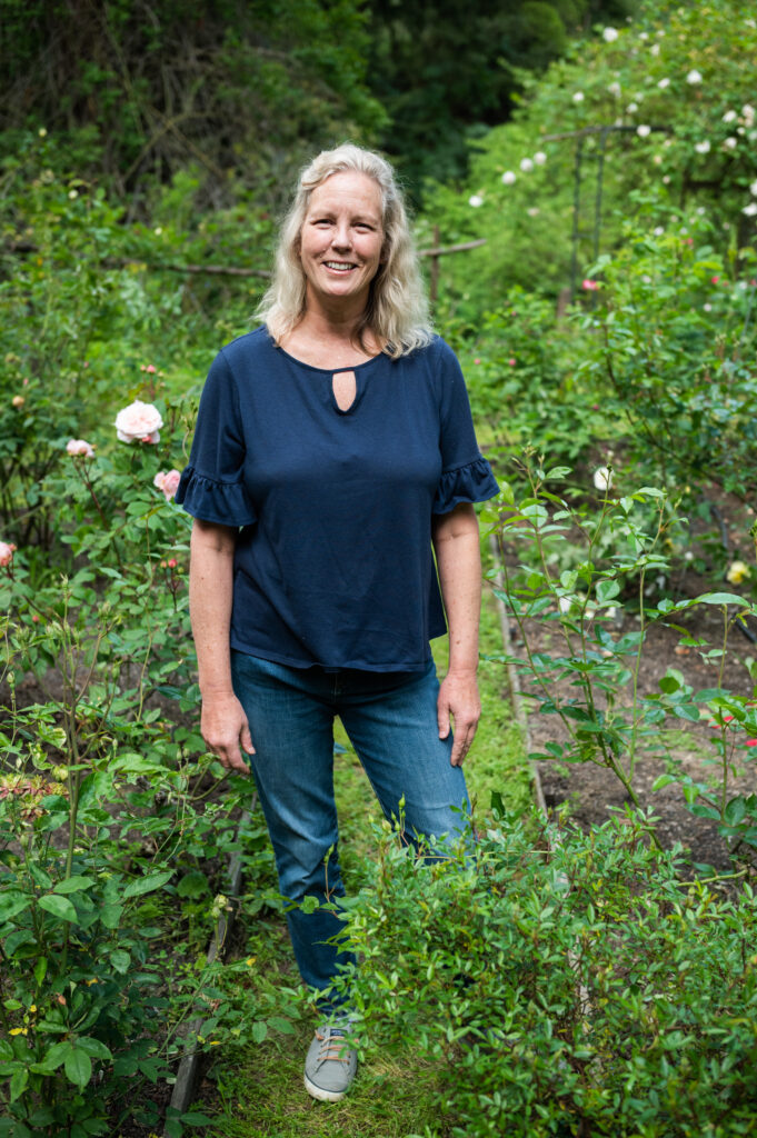 woman standing in the garden of Roses of Yesterday and Today